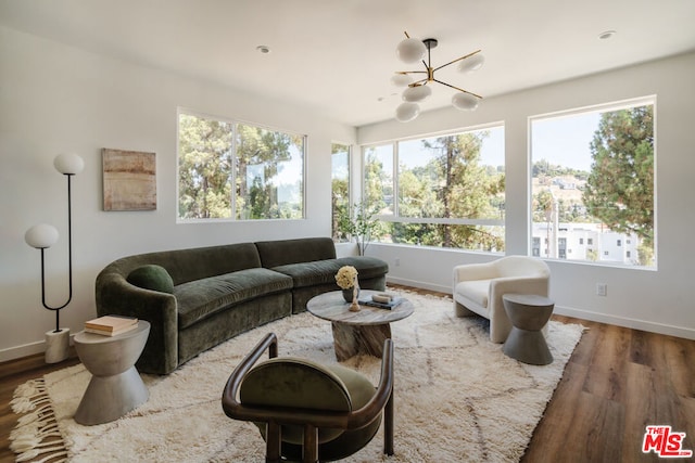 interior space with hardwood / wood-style floors, a healthy amount of sunlight, and an inviting chandelier