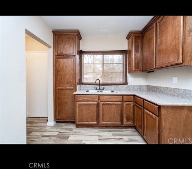 kitchen with sink and light hardwood / wood-style flooring