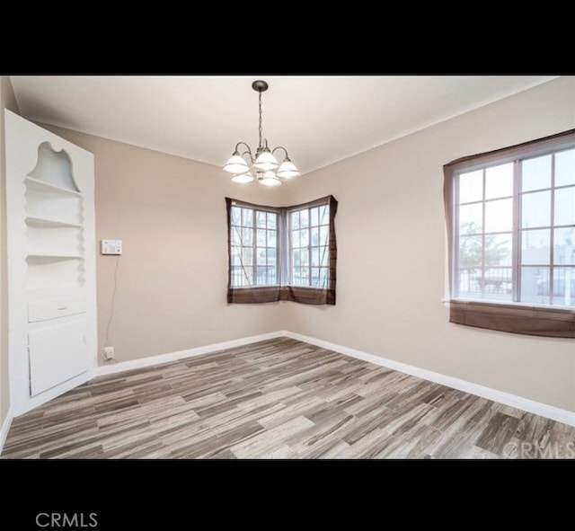 interior space featuring hardwood / wood-style flooring, plenty of natural light, and a notable chandelier