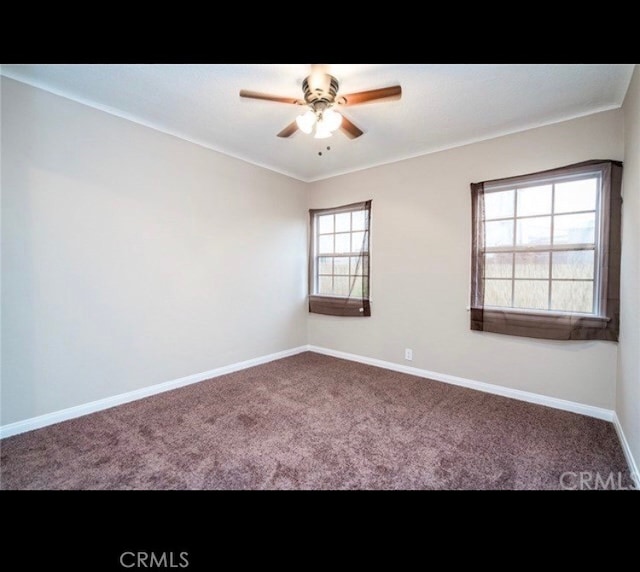 carpeted spare room featuring ceiling fan