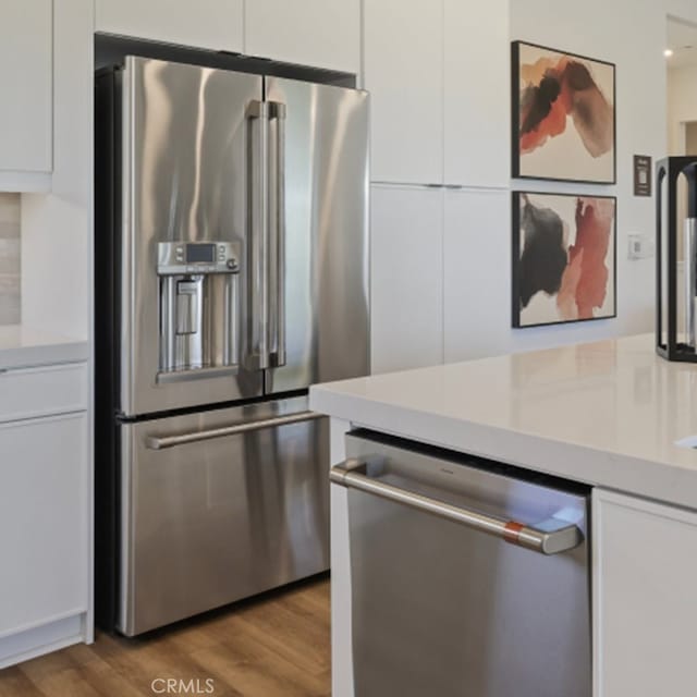 kitchen with white cabinetry, hardwood / wood-style floors, and stainless steel appliances