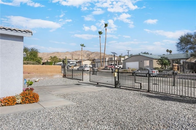 view of gate featuring a mountain view and an outdoor structure