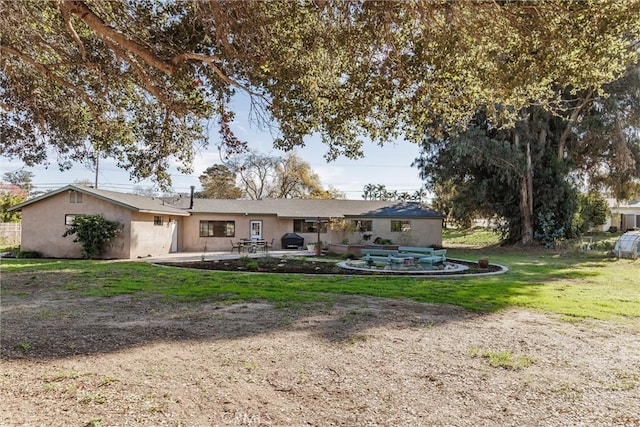 rear view of house with a lawn and a patio area