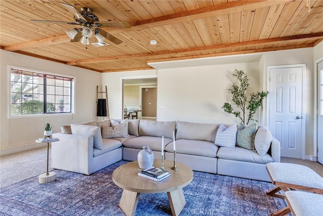 living room with ceiling fan, beamed ceiling, carpet floors, and wooden ceiling