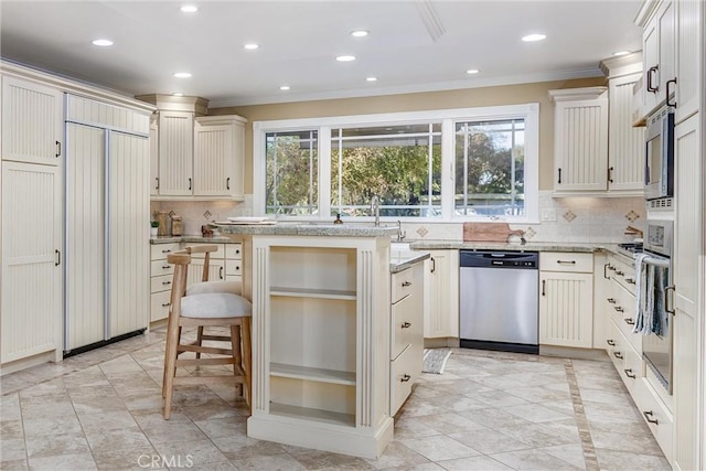 kitchen with dishwasher, paneled refrigerator, backsplash, crown molding, and a kitchen bar