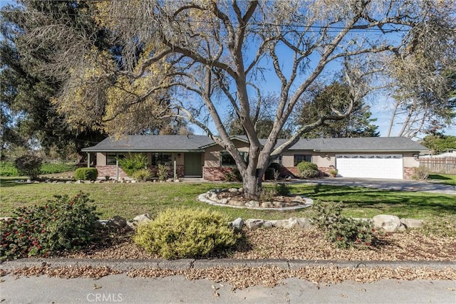 ranch-style house featuring a front yard and a garage