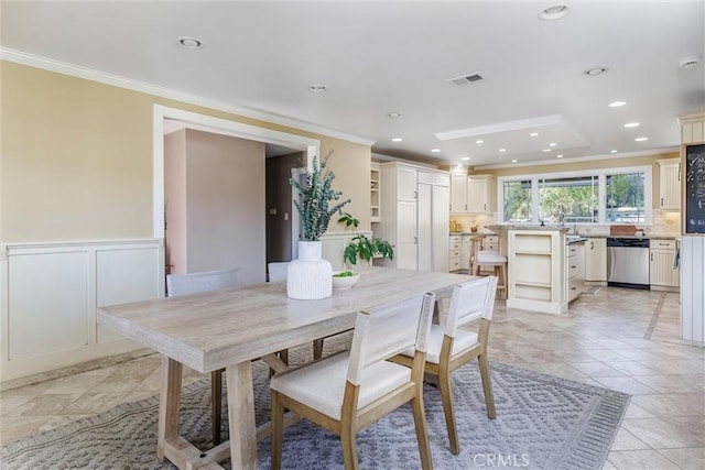 tiled dining space featuring crown molding