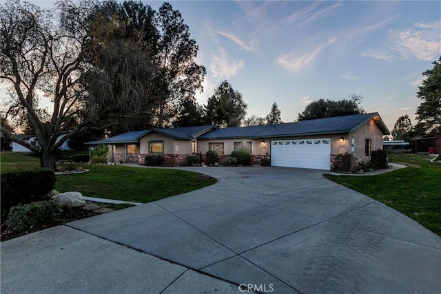 ranch-style house with a yard and a garage