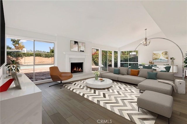 living room featuring hardwood / wood-style floors, lofted ceiling, and a notable chandelier