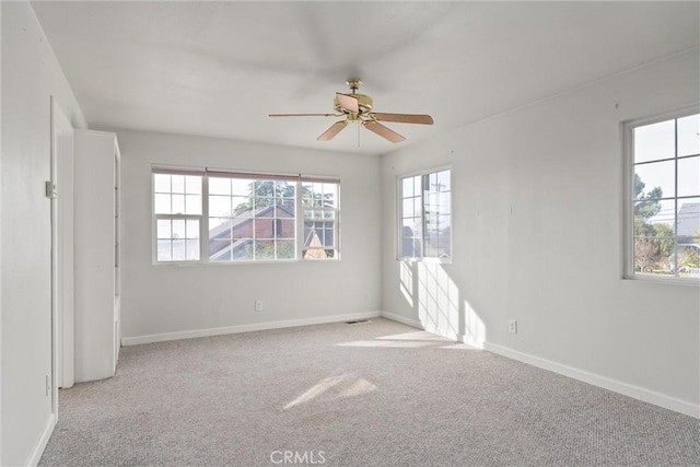 carpeted spare room with ceiling fan