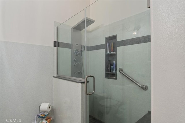 bathroom featuring toilet and an enclosed shower