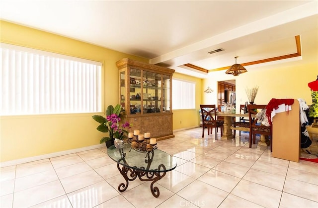 sitting room with light tile patterned floors, a tray ceiling, and ornamental molding