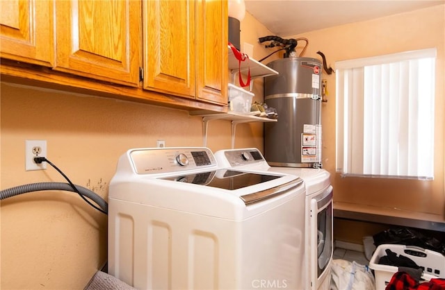 laundry area featuring secured water heater, cabinets, and washing machine and clothes dryer