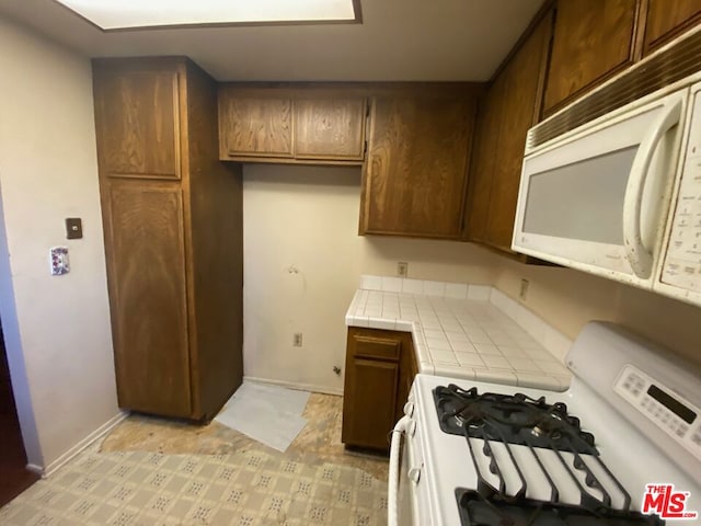 kitchen featuring tile counters and white appliances