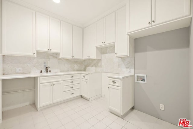 kitchen featuring backsplash, white cabinetry, and sink