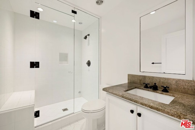 bathroom with a shower with door, vanity, and toilet