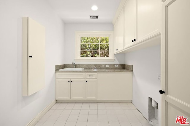 clothes washing area featuring sink and light tile patterned floors