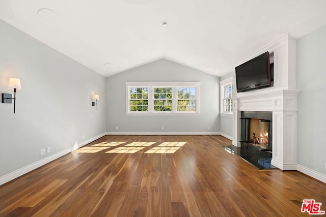 unfurnished living room with a fireplace, wood-type flooring, and vaulted ceiling