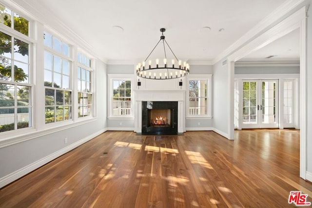 unfurnished living room with hardwood / wood-style flooring, plenty of natural light, and ornamental molding