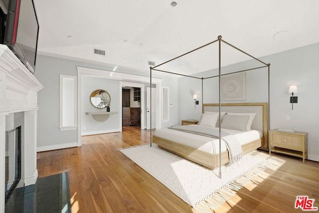 unfurnished bedroom featuring hardwood / wood-style flooring and vaulted ceiling