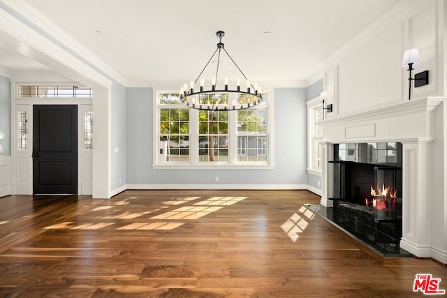 interior space featuring crown molding, hardwood / wood-style floors, a high end fireplace, and a chandelier