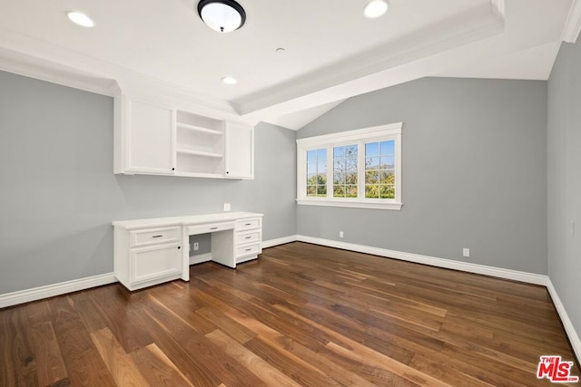 unfurnished office with dark hardwood / wood-style flooring, built in desk, crown molding, and vaulted ceiling