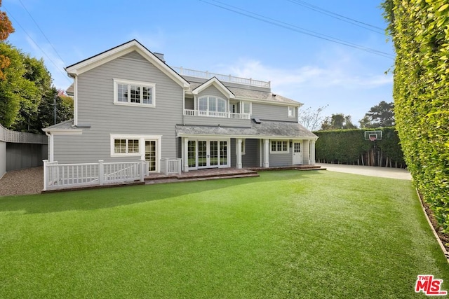 back of house featuring a yard and a balcony