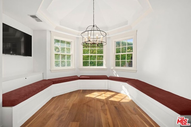 unfurnished dining area with a chandelier, wood-type flooring, and plenty of natural light