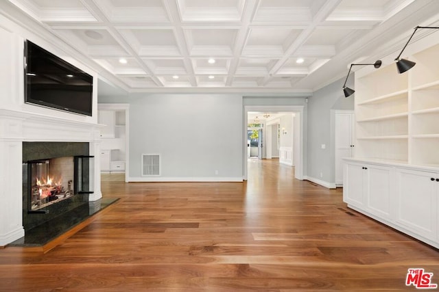 unfurnished living room featuring hardwood / wood-style flooring, a fireplace, beamed ceiling, and coffered ceiling