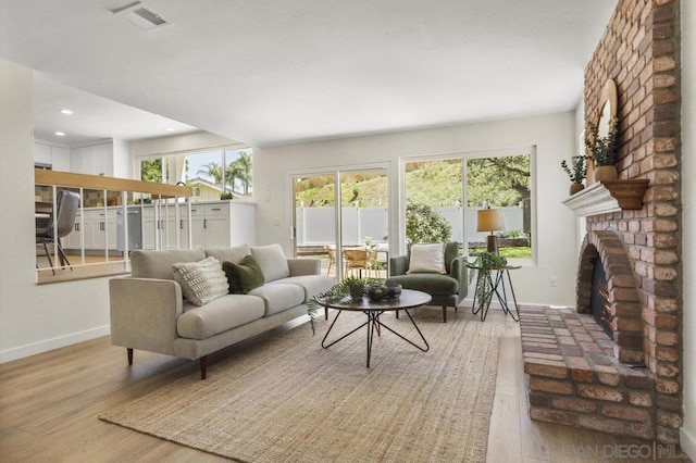 living room with light hardwood / wood-style floors and a fireplace