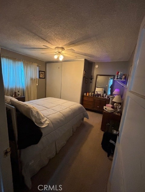 carpeted bedroom with a textured ceiling and ceiling fan