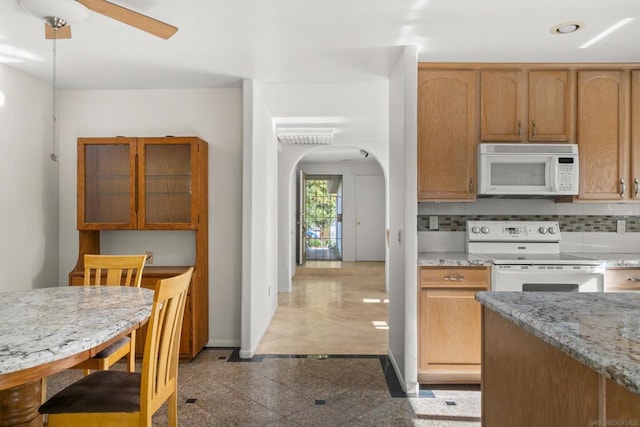 kitchen featuring decorative backsplash, electric range oven, light stone counters, and ceiling fan