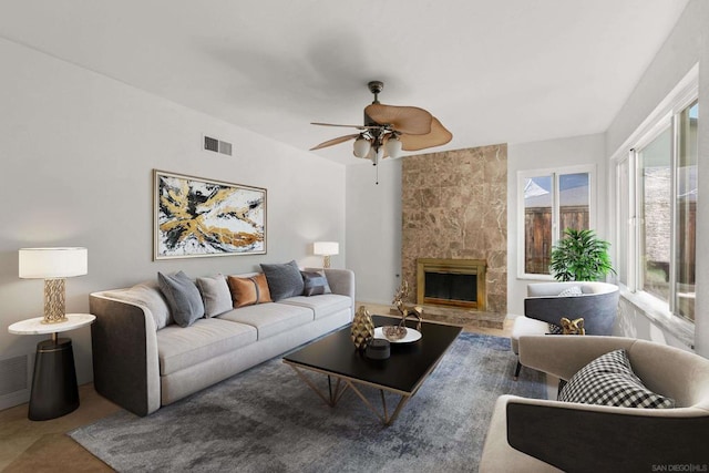 living room with ceiling fan and a fireplace