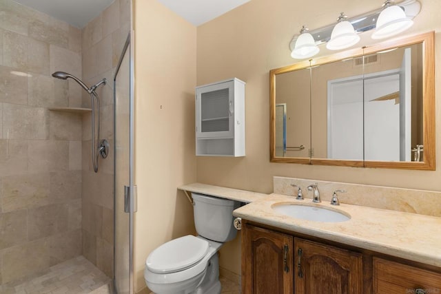 bathroom featuring a shower with door, toilet, and vanity