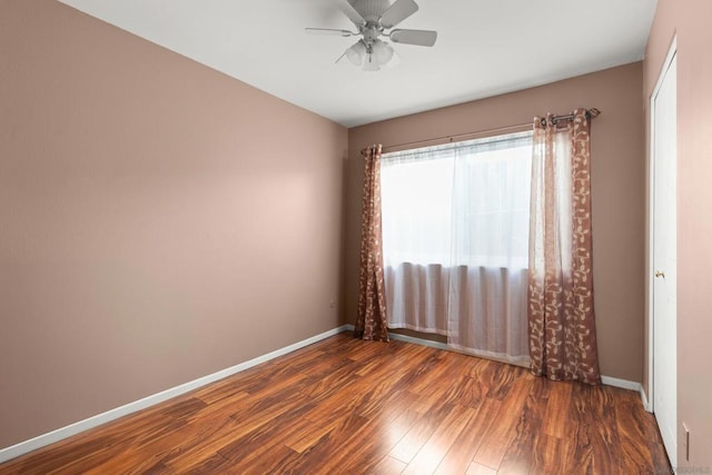 unfurnished room with ceiling fan and dark wood-type flooring