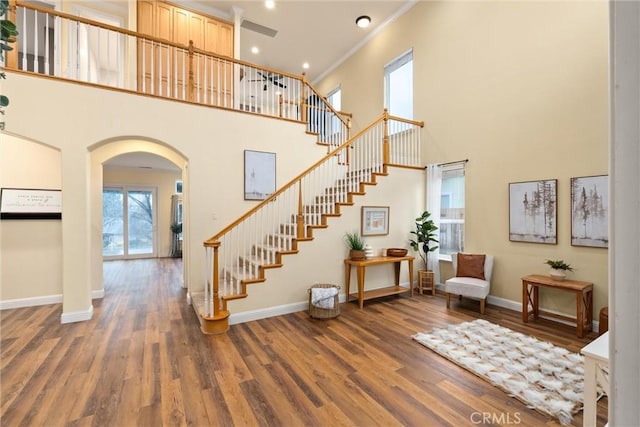 foyer featuring a high ceiling, dark hardwood / wood-style flooring, and crown molding