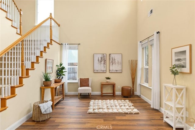 sitting room with a high ceiling and dark hardwood / wood-style flooring