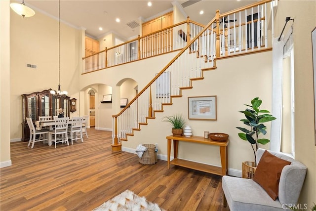 staircase featuring a towering ceiling and hardwood / wood-style floors