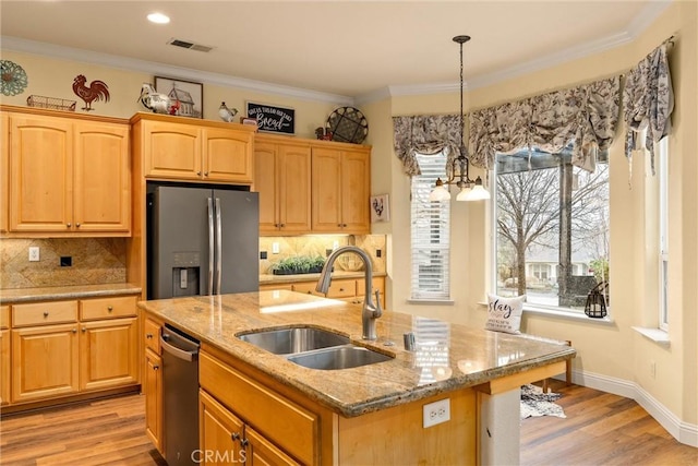 kitchen featuring an island with sink, sink, hanging light fixtures, stainless steel fridge with ice dispenser, and a notable chandelier