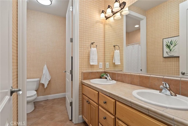 bathroom featuring toilet, vanity, and tile patterned flooring