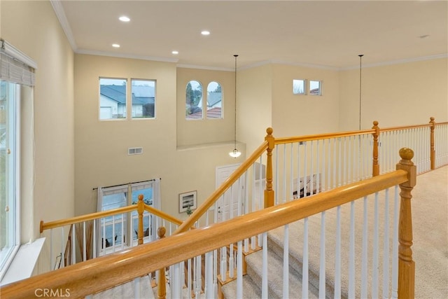 staircase with crown molding and carpet flooring