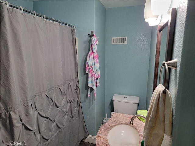 bathroom with a shower with curtain, sink, and toilet