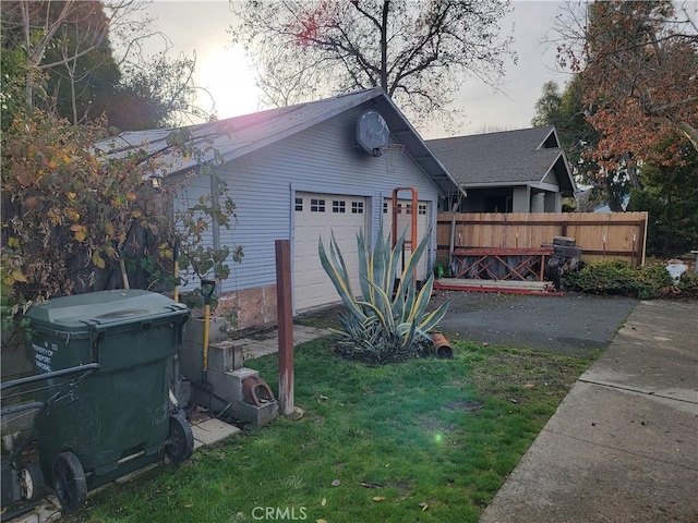 view of side of home with a garage, an outbuilding, and a lawn