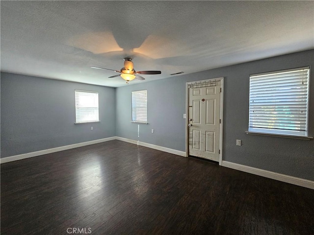 empty room featuring ceiling fan, dark hardwood / wood-style flooring, and a textured ceiling