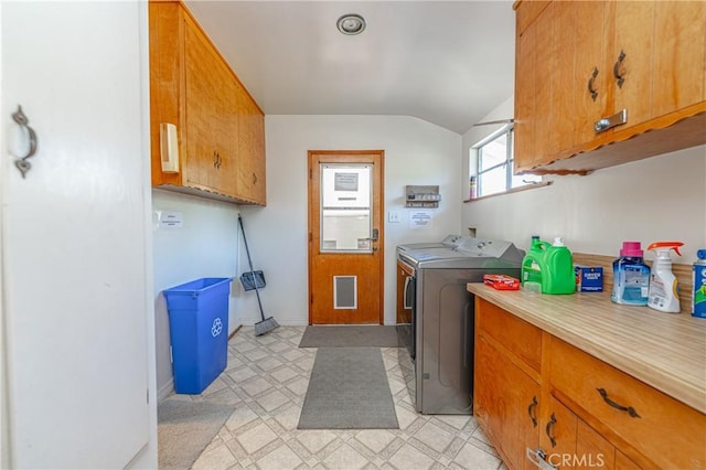 clothes washing area featuring washing machine and clothes dryer and cabinets