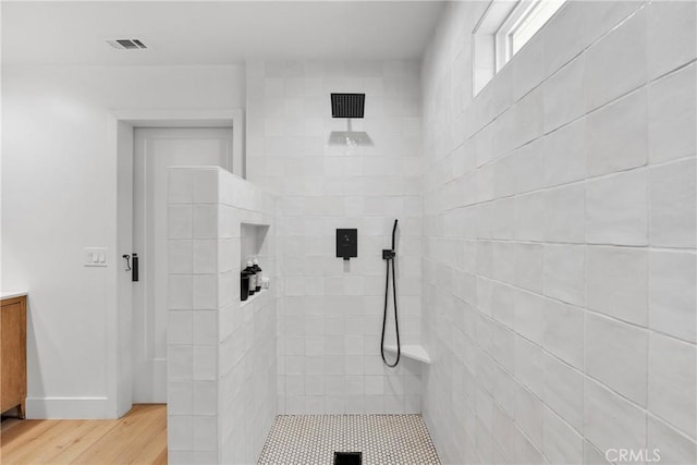 bathroom featuring tiled shower and hardwood / wood-style floors