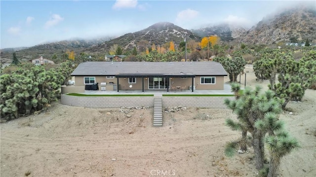 back of house featuring a mountain view and a patio