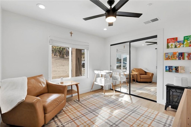 living area featuring ceiling fan and light hardwood / wood-style floors