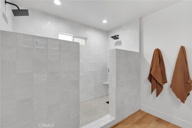 bathroom featuring hardwood / wood-style floors and tiled shower