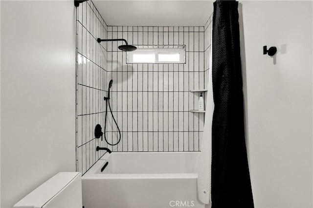 bathroom with tiled shower / bath combo and toilet